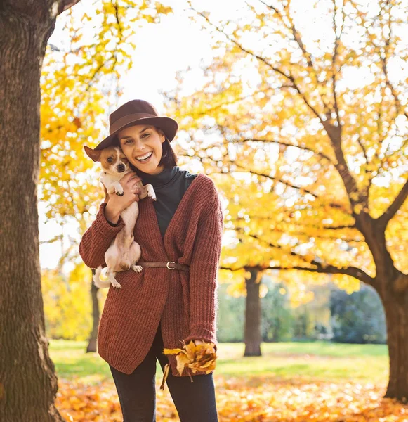 Porträtt av leende ung kvinna med hund utomhus i höst — Stockfoto