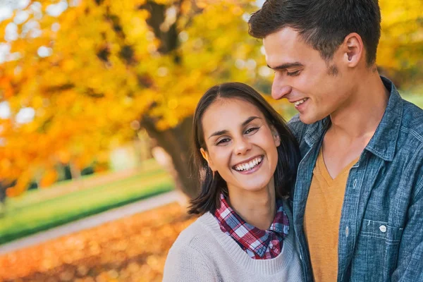 Sorrindo jovem casal ao ar livre no parque no outono — Fotografia de Stock