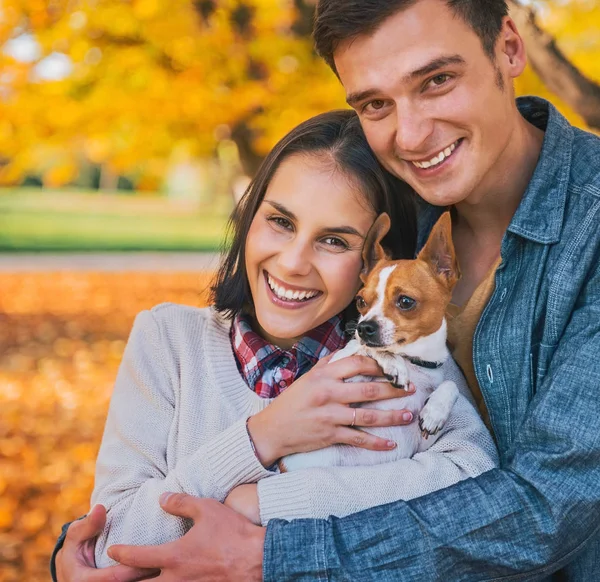 Retrato de jovem casal feliz com cão ao ar livre no outono — Fotografia de Stock