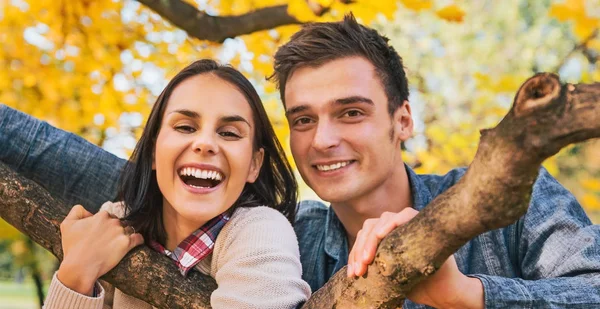 秋に屋外若いカップルを笑顔の肖像画 — ストック写真