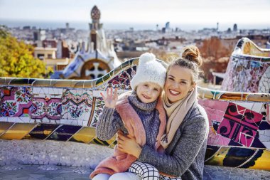 Anne ve çocuk bankta otururken Barcelona handwaving içinde
