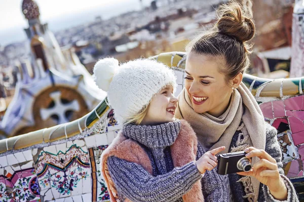 Happy mother and child viewing photos on camera at Guell Park — Stock Photo, Image