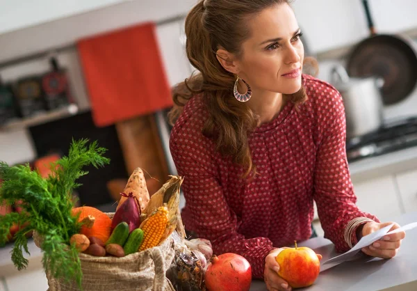 Jonge huisvrouw met controles na de boodschappen te doen — Stockfoto