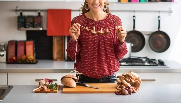 Junge Hausfrau trocknet Pilze — Stockfoto