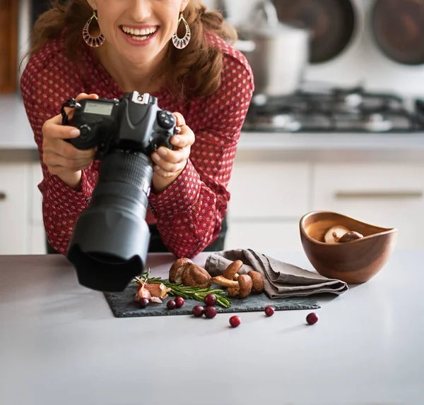 Улыбающаяся женщина пищевой фотограф смотрит вверх от еды — стоковое фото