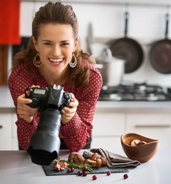 Mujer sonriente fotógrafa de comida mirando hacia arriba desde la comida — Foto de Stock