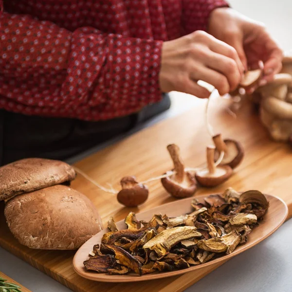 Closeup seen from above of mushrooms being strung together — Stock Photo, Image