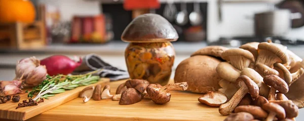 Close-up op pot van ingemaakte paddenstoel op snijplank — Stockfoto