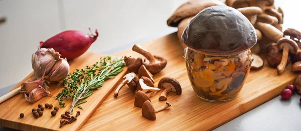 Close-up op pot van ingemaakte paddenstoel op snijplank — Stockfoto