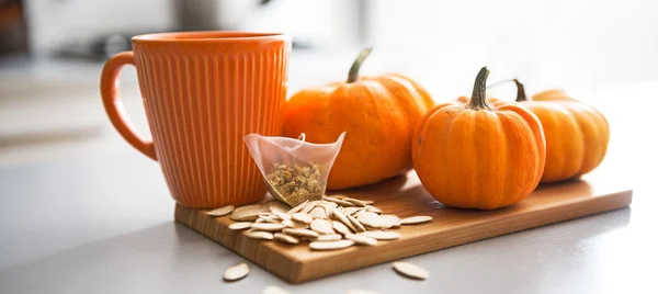 Closeup on small pumpkins seeds and tea bag on table — Stock Photo, Image