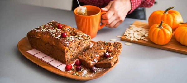 Pan de calabaza hecho en casa en rodajas, manos de mujer y té — Foto de Stock