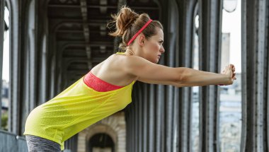 Paris Pont de Bir-Hakeim köprüde germe kadın koşucu