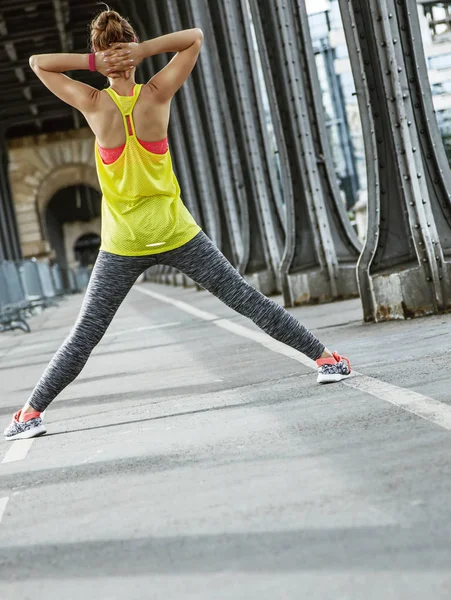 Vrouw jogger uitrekken op Pont de Bir-Hakeim brug in Parijs — Stockfoto