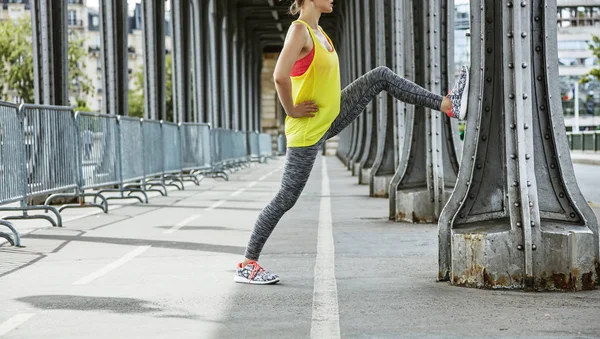 Sportvrouw die zich uitstrekt over de Pont de Bir-Hakeim brug in Parijs — Stockfoto