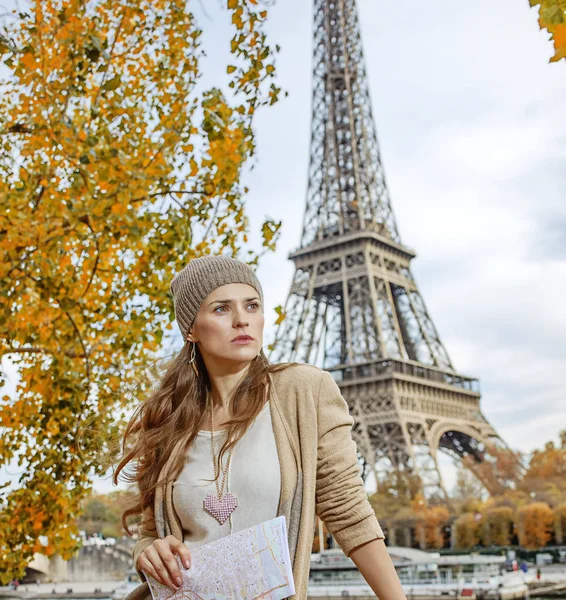 Vrouw met kaart op zoek naar afstand aan kade in Parijs — Stockfoto