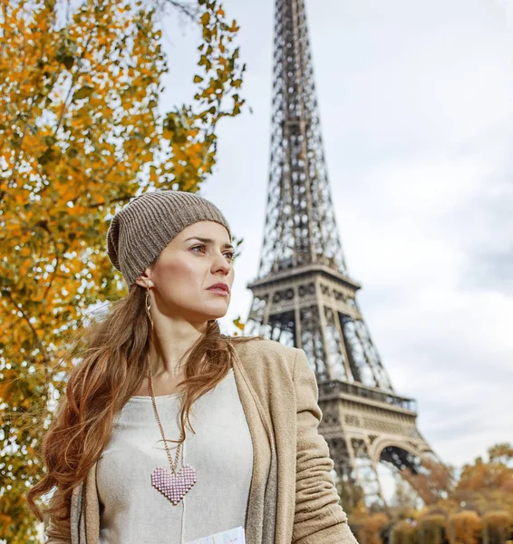 Kobieta z mapą patrząc na odległość na nasyp w Paryżu — Zdjęcie stockowe