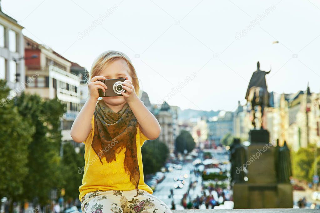 modern child with digital camera taking photo in Prague