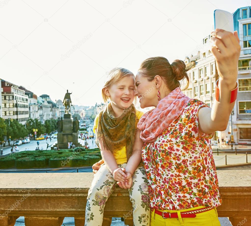 mother and child tourists in Prague taking selfie with phone