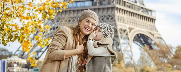 Dcera, šeptající něco matka blízko: Eiffel tower — Stock fotografie