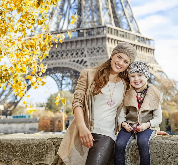 Mor og barn turister sidder på brystværnet i Paris - Stock-foto