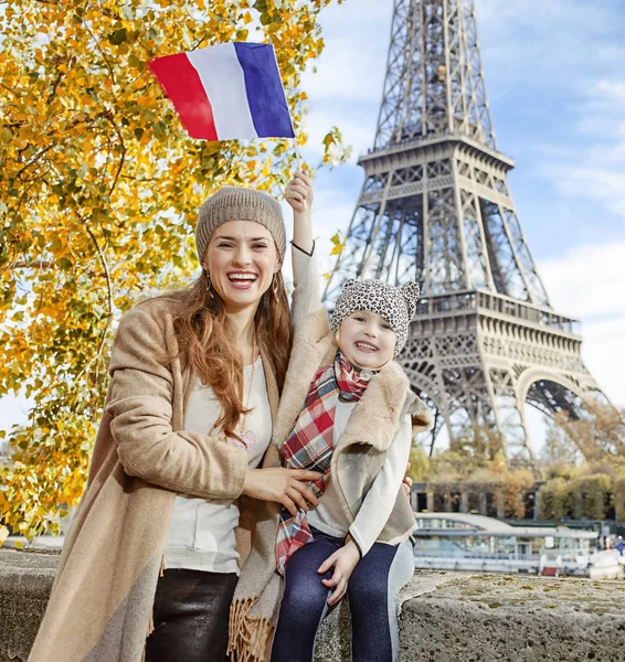 Mor och dotter stigande flagga när du sitter på parapeten, Paris — Stockfoto