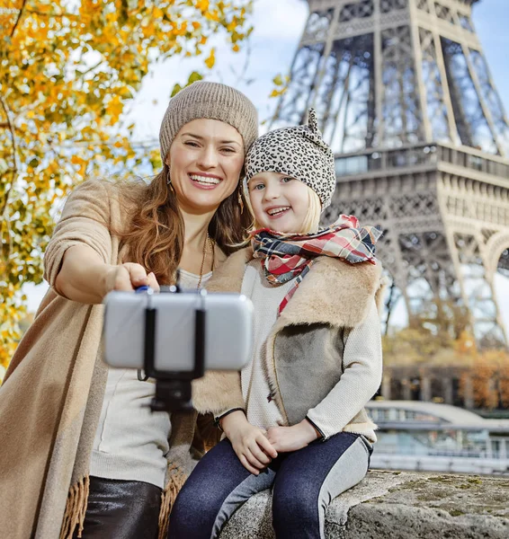 smiling mother and daughter travellers taking selfie in Paris