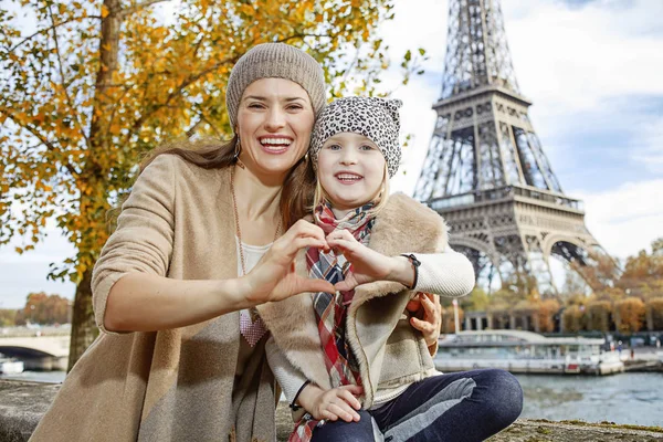 Mother and daughter tourists in Paris showing heart shaped hands — Stock Photo, Image