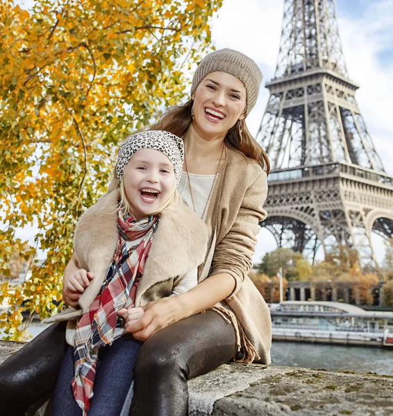 Mor og barn rejsende sidder på brystværnet i Paris - Stock-foto