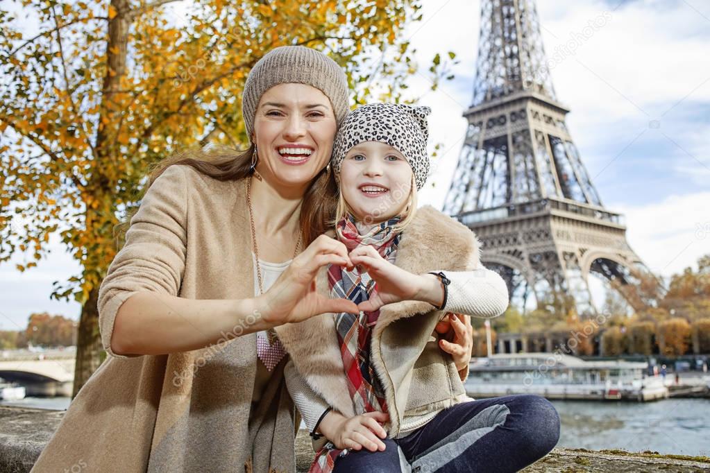 mother and daughter tourists in Paris showing heart shaped hands