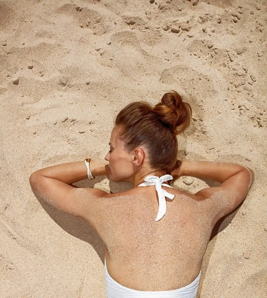 水着の砂の上に置くことで女性の後ろから見てください。 — ストック写真