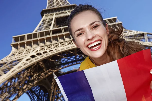 Lachende jonge vrouw vlag tonen in Parijs, Frankrijk — Stockfoto