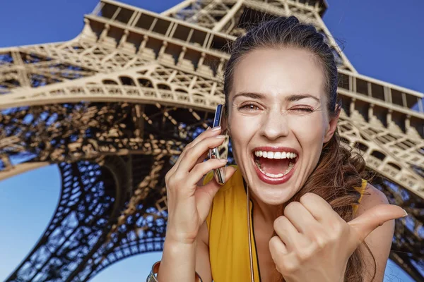 Женщина, показывающая большие пальцы и говорящая по мобильному телефону в Париже — стоковое фото