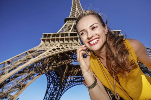 Glad ung kvinna använder mobiltelefon mot Eiffeltornet, Paris — Stockfoto