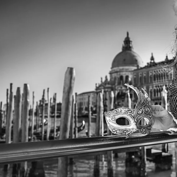 Primer plano de la máscara veneciana en la mano de la mujer en el terraplén — Foto de Stock