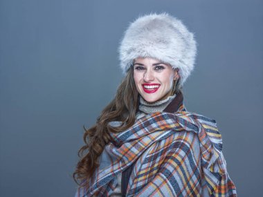 Kış şeyler. Kürk şapka mavi arka plan üzerinde mutlu genç kadın portresi 