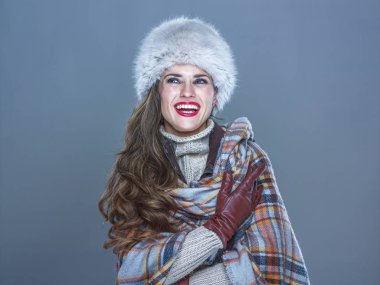 Kış şeyler. Kürk şapka mavi arka plan üzerinde mutlu genç kadın portresi 