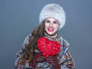 Kış şeyler. Soğuk ile kırmızı kalp mavi kürk şapka içinde gülümseyen zarif kadın portresi