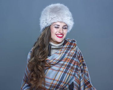 kürk şapka soğuk mavi gülüyor üzerinde izole mutlu genç kadın