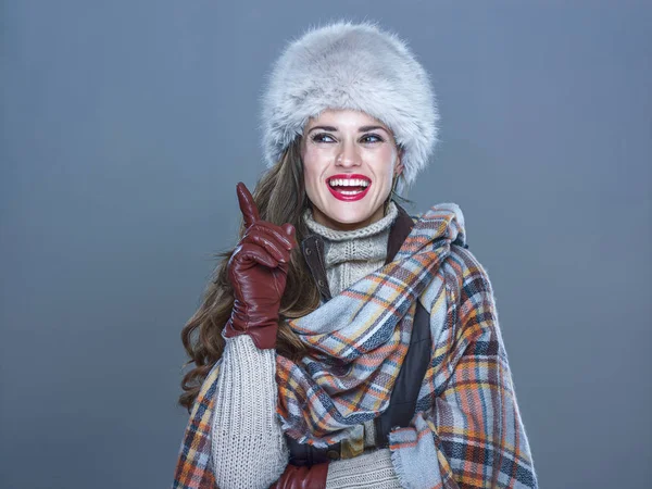 Sonriente elegante mujer en piel sombrero aislado en frío azul tiene idea — Foto de Stock