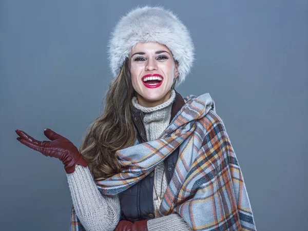 Retrato de una mujer sonriente mostrando algo en la mano vacía —  Fotos de Stock