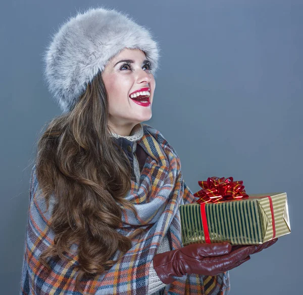 Felice donna isolata su sfondo blu freddo dando scatola regalo — Foto Stock