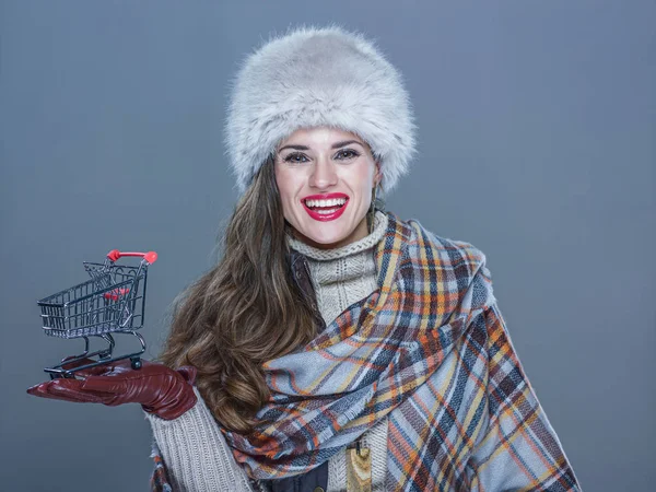 Mujer aislada sobre fondo azul frío mostrando carro de la compra — Foto de Stock