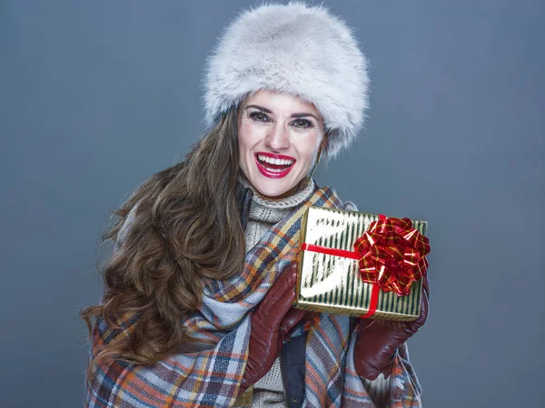 Feliz joven mujer aislado en frío azul mostrando presente caja — Foto de Stock