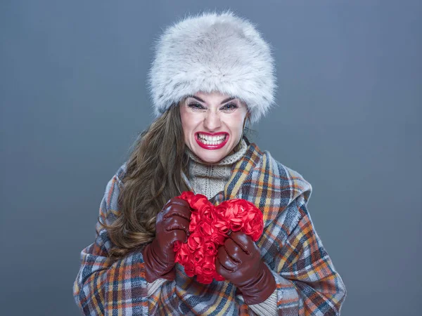 Mujer enojada aislada sobre fondo azul frío aplastando el corazón rojo —  Fotos de Stock