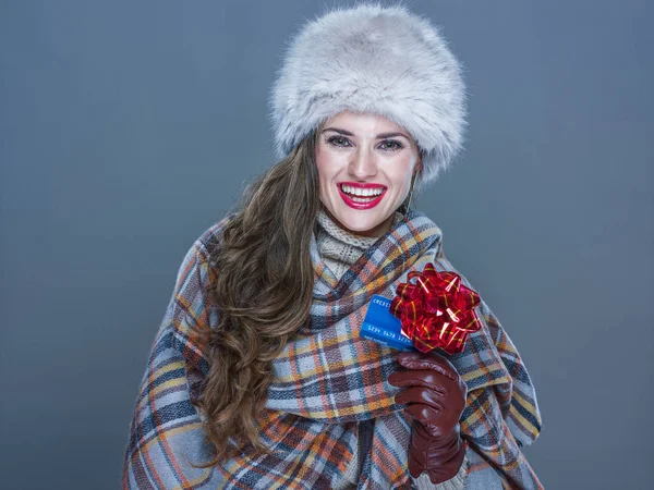 Mujer feliz aislada en azul frío mostrando tarjeta de crédito con r rojo — Foto de Stock