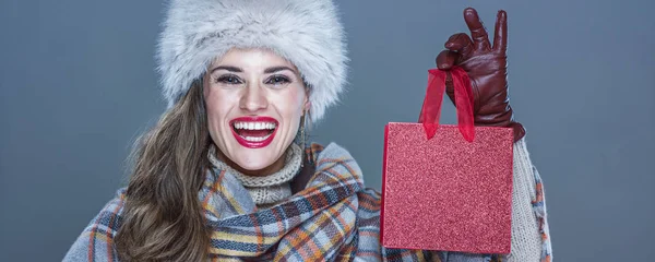 Porträt einer lächelnden eleganten Frau mit einer kleinen roten Einkaufstasche — Stockfoto