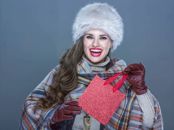 Retrato de mujer elegante sonriente sosteniendo una pequeña bolsa de compras roja — Foto de Stock