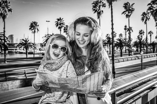 Mother and child travellers on embankment looking at map, Spain — Stock Photo, Image