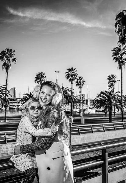 Mother and child tourists on embankment in Barcelona hugging — Stock Photo, Image