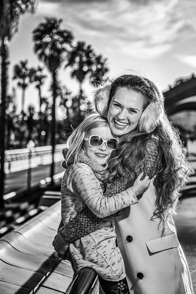 Mother and daughter tourists on embankment in Barcelona hugging — Stock Photo, Image